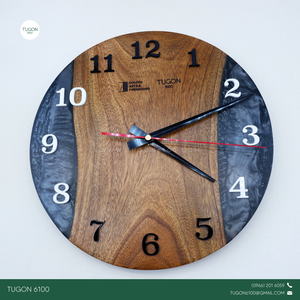 Bring timeless style to your space with "Cael", a 12-inch round wall clock that blends elegant design with industrial charm. Handcrafted using a unique combination of wood, resin, and acrylic, this statement piece adds depth, character, and modern sophistication to any room.

Perfect for home interiors, office walls, or business spaces, Cael doesn’t just tell time — it tells your story. With options for custom engraving or logo placement, it also makes a standout choice for corporate gifts, housewarming pre